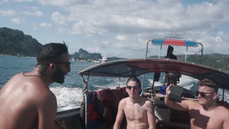 Tourists-on-longtail-boat-cruising-through-Phi-Phi-island,-enjoying-their-vacation
