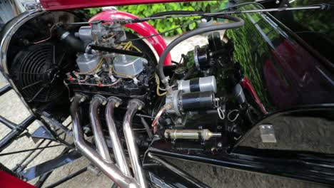 Roter-1939-Morgan-4-4-&#39;le-Mans&#39;---Motordetail-Unter-Der-Motorhaube---Slomo---Offener-Sportwagen-In-Englischer-Landschaft-An-Einem-Perfekten-Tag