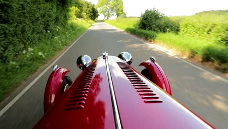 Roter-1939-Morgan-4-4-&#39;le-Mans&#39;---Motorhaubenperspektive---Slomo---Offener-Sportwagen-In-Englischer-Landschaft-An-Einem-Perfekten-Tag