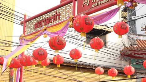 Red-Lanterns-Hanging-From-Wire-Across-A-Street,-Chinese-New-Year