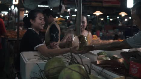 Fruit-vendor-cutting-open-coconut-for-sale,-street-food-in-Thailand,-slow-motion