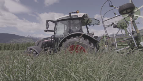 Traktor,-Der-Auf-Alpenwiese-Arbeitet-Und-Frisches-üppiges-Gras-Für-Futter-Mäht