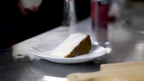 Zucker-Auf-Eine-Scheibe-Crème-Brûlée-Käsekuchen-In-Einem-Teller-Streuen---Nahaufnahme,-Zeitlupe