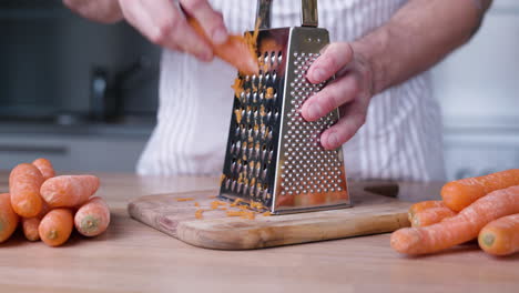 Male-Hands-Grating-Carrots-on-Cutting-Board