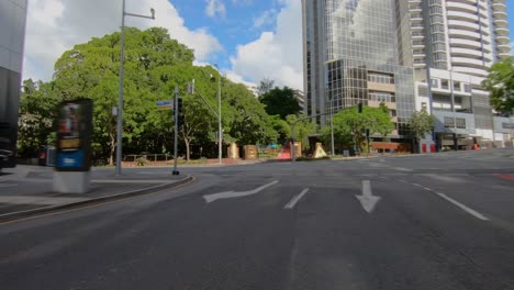 Rear-facing-driving-point-of-view-POV-of-city-central-business-district-CBD,-on-deserted-roads,-with-intersections-and-modern-tower-blocks---ideal-for-interior-car-scene-green-screen-replace