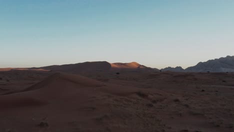 Drone-Flying-Across-Arid-Desert-On-An-Early-Morning---low-aerial
