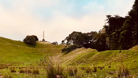 Zeitraffer-Mit-Blick-Nach-Oben-über-Einen-Grasbewachsenen-Hügel-An-Einem-Baumhügel-In-Auckland,-Neuseeland,-Während-Eines-Hellen-Tages