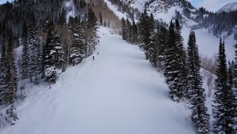 Esquiadores-Y-Practicantes-De-Snowboard-Corren-Por-La-Ladera-De-Una-Montaña-Cubierta-De-Nieve-En-Utah