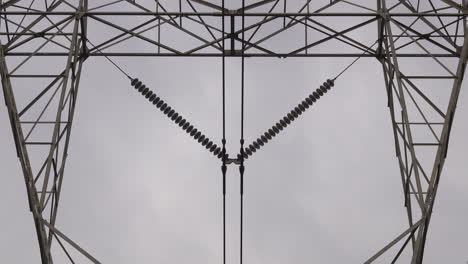 Close-up-of-electrical-insulators-and-electrical-pylon-tower-structure