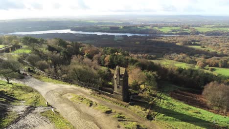 Historic-creepy-fairy-tale-Rivington-pigeon-tower-aerial-slow-rising-overlooking-English-Winter-hill-farming-countryside
