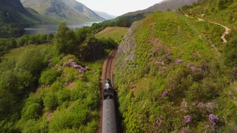 Scotland-Steam-Train-Drone-Following-Shot-Reveal-of-Converging-Mountains-in-Distance