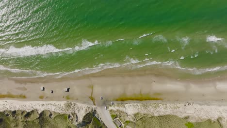 Aerial-view,-waves-of-the-North-Sea-wash-the-sand-of-the-wild-beach