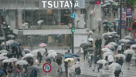 Crowd-Of-People-With-Umbrella-On-A-Rainy-Day-Cross-At-Shibuya-Crossing-In-Front-Of-Tsutaya-Building-In-Tokyo,-Japan