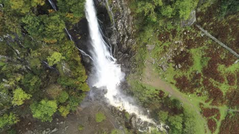 Idyllic-Snowdonia-mountain-range-Aber-falls-cascading-waterfalls-national-park-aerial-birds-eye-view