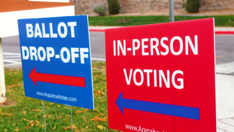 Blaues-Wahlzettel-Abgabeschild-Mit-Rotem-Persönlichen-Abstimmungsschild,-Das-Draußen-Im-Wind-Weht