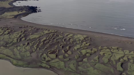 Aerial-of-distinctive-black-volcanic-Sandvik-beach-on-rugged-shores-of-Iceland