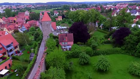 aerial-view-over-the-city-stone-wall-with-towers-on-the-right-side-is-a-green-park-and-on-the-left-the-old-town-and-the-houses-with-red-roofs