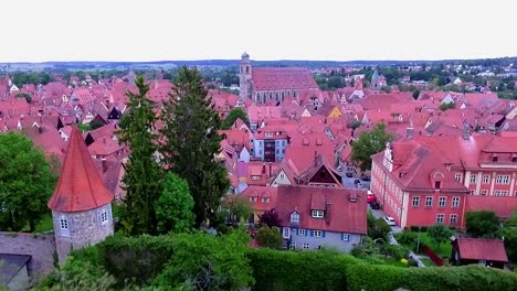 a-drone-flies-backwards-over-the-old-town-and-the-red-roofs-of-the-houses-and-the-city's-green-park-aerial-view