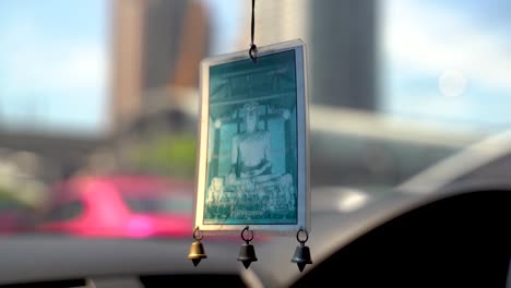 Close-up-shot-of-an-image-of-a-buddha-hanging-inside-of-a-car