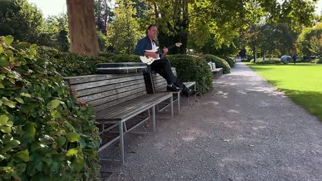 Ein-Mann-Spielt-Die-Weiße-Gitarre-Im-Park