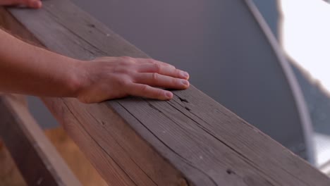 Zwei-Männliche-Hände-Auf-Einem-Holzbalken-Vom-Geländer