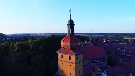 a-drone-rises-slowly-past-the-tower-of-an-ancient-city-beautiful-panorama-to-the-landscape-of-the-old-town-horizon-at-sunset-aerial-view