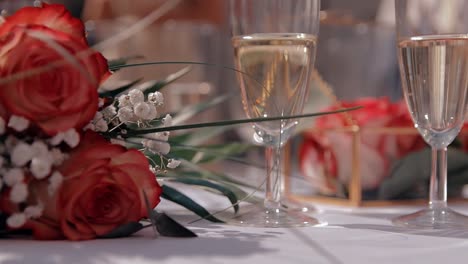 Hochzeitsstrauß-Mit-Zwei-Gläsern-Champagner-Auf-Einem-Tisch-Mit-Einer-Weißen-Tischdecke,-Die-Für-Das-Hochzeitspaar-Vorbereitet-Wurde
