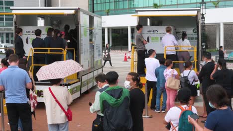Chinesische-Einwohner-Stehen-Schlange,-Um-Pcr-tests-Auf-Coronavirus-Von-Lastwagen-Des-Kommunalen-Testzentrums-Zu-Erhalten,-Um-Die-Ausbreitung-Des-Virus-Und-Der-Pandemie-In-Hongkong-Zu-Bekämpfen