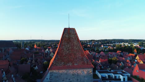 Luftaufnahme-Eine-Drohne-Erhebt-Sich-Langsam-Gegen-Einen-Turm-Im-Hintergrund-Zeigt-Das-Historische-Stadtpanorama-Mit-Blauem-Himmel