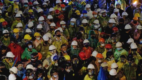 Thailändische-Demonstranten-Mit-Schutzhelmen-Und-Schutzbrillen-Warten-In-Der-Menge