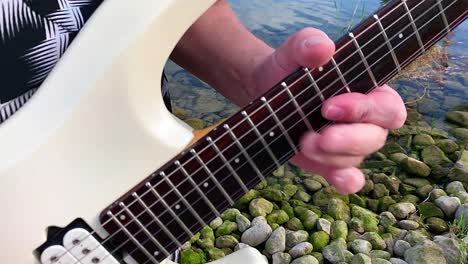 Ein-Gitarrist-Spielt-In-Der-Nähe-Des-Wassers-Des-Sees