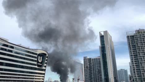 Huge-Smoke-From-Burnt-Building-Near-The-Unilever-Building-Along-Rama-IX-Road,-Huai-Khwang,-Bangkok---tilt-down-shot