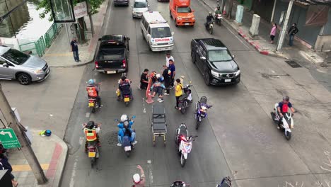 Ambulancia-Y-Equipo-Médico-En-La-Escena-De-Un-Accidente-Vehicular-En-Bangsue,-Bangkok,-Tailandia,-Acercándose-Al-Automovilista-Herido-Tirado-En-La-Calle---Tiro-De-ángulo-Alto