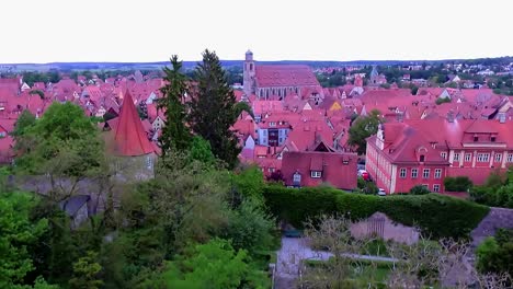 Eine-Drohne-Senkt-Sich-Im-Park-Mit-Panorama-Auf-Die-Altstadt-Luftaufnahme