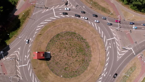 Aerial-birds-eye-overhead-top-down-of-a-dutch-double-lane-roundabout-with-moderate-traffic-driving-round,-shot-turning-along-with-cars
