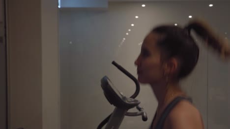 Young-woman-running-on-a-treadmill-inside-a-gym,-concept-for-discipline-and-motivation