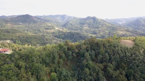 Bewaldete-Hügel-In-Der-Landschaft-Italiens-Mit-Einem-Ferienhaus,-Drohnenluftaufnahme