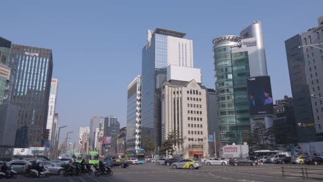 Gangnam-daero-crossroad-traffic-with-a-view-of-Glass-Tower,-Iz-Tower,-Medi-Tower-in-Seoul-downtown-on-sunny-day