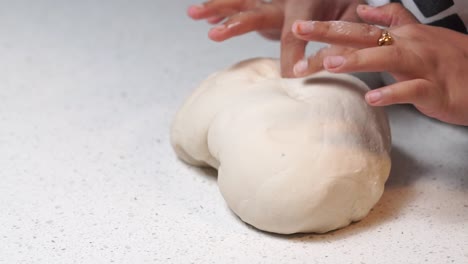 kneading-white-dough-with-hands-on-white-table-slow-motion