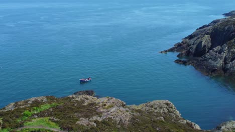 Boat-fishing-on-Amlwch-Anglesey-North-Wales-rugged-mountain-coastal-walk-aerial-view-zoom-in