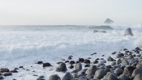 Crashing-white-foam-waves-on-rocky-boulder-beach-in-Iceland,-slow-motion