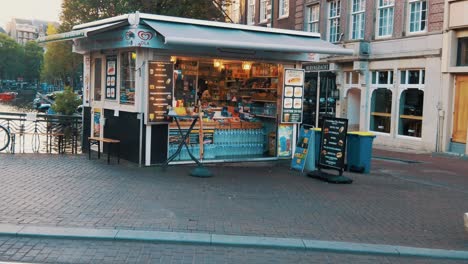 small-outside-newspaper-stand-on-a-canal-bridge-in-the-middle-of-Amsterdam,-Netherlands