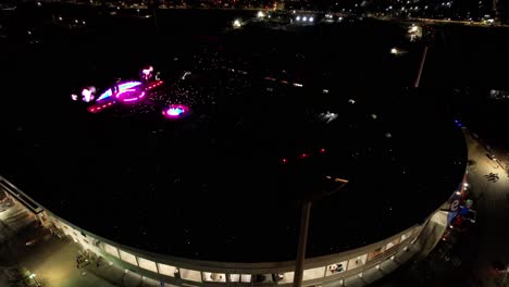 Aerial-orbiting-national-stadium-of-Chile-during-World-tour-of-Coldplay,-Crowded-Stadium-with-light-show
