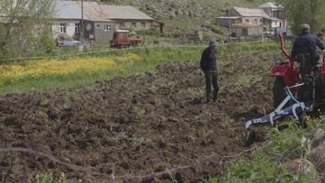 Men-In-The-Field-With-Farm-Tractor-Ploughing-During-Daytime-In-Moliti-Village,-Georgia