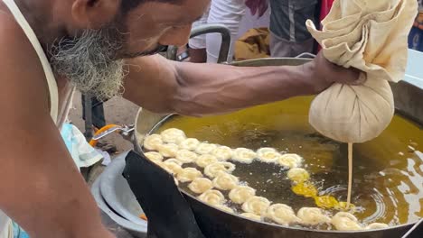 Vendedor-Ambulante-Cocinando-Bocadillos-Dulces-Jalebi-Al-Aire-Libre-En-El-Mercado-De-La-Calle-Iftar,-Dhaka,-Bangladesh
