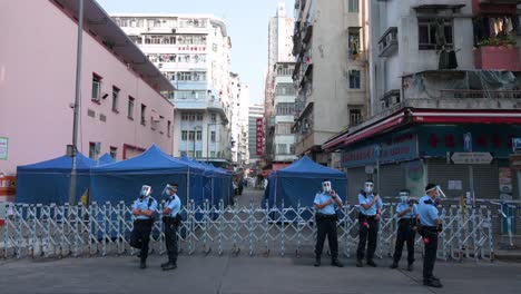 Los-Agentes-De-Policía-Montan-Guardia-Frente-A-Una-Barrera-En-Una-Zona-Residencial-Bajo-Encierro-Para-Contener-La-Propagación-Del-Brote-De-La-Variante-Del-Coronavirus-En-Hong-Kong