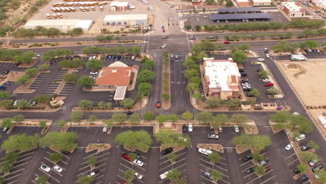 Aerial-of-shopping-mall-and-parking-lot-in-Southern-Arizona,-drone-sideways