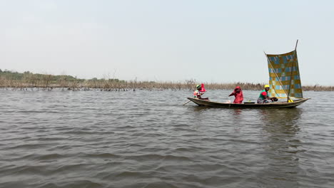 Villagers-Riding-On-A-Boat-Across-Lake-Nokoue-In-Ganvie,-Benin,-West-Africa