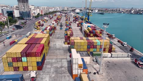 Aerial-view-of-a-cargo-shipping-dock-with-lots-of-colorful-large-containers,-tracking-wide-shot