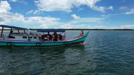 happy-tourists-on-a-boat-tour-during-a-sunny-day-in-Belitung-Indonesia,-aerial